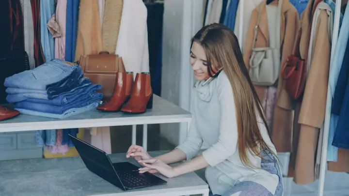 Boutique owner checking orders on a laptop